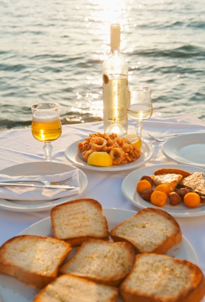 Greece, Cyclades Islands, Mykonos, Calamari appetizer on set table by sea.