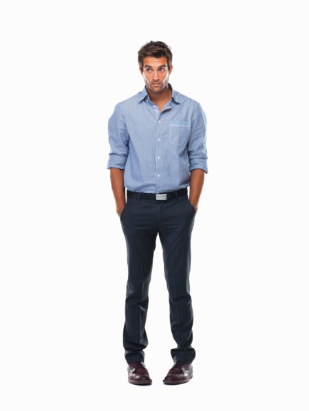 Worried executive standing with hands in pockets against white background. Photo : momentimages