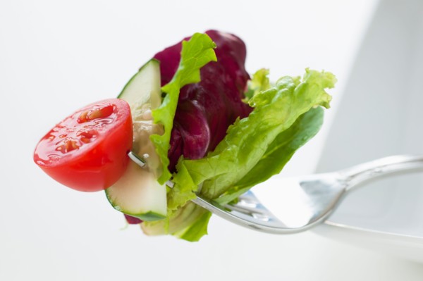 Fresh salad on fork.