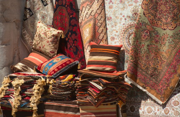 Turkey, Istanbul, Grand Bazaar, rugs and cushions for sale.