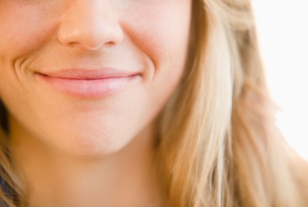 Close up of mouth of smirking woman. Photo : Jamie Grill