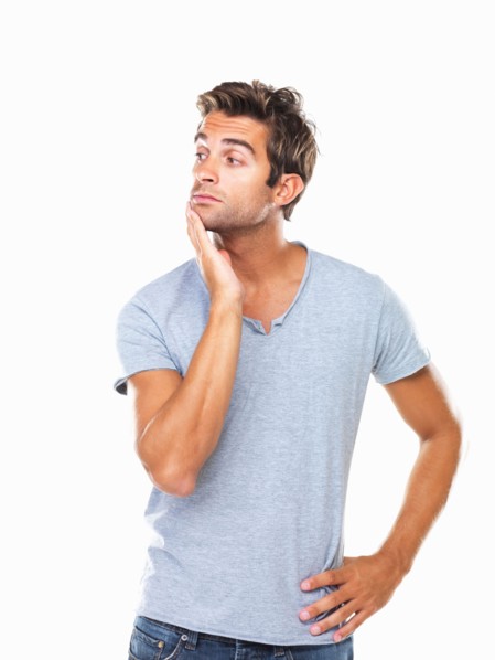 Studio shot of thoughtful young man with hand on chin. Photo : momentimages