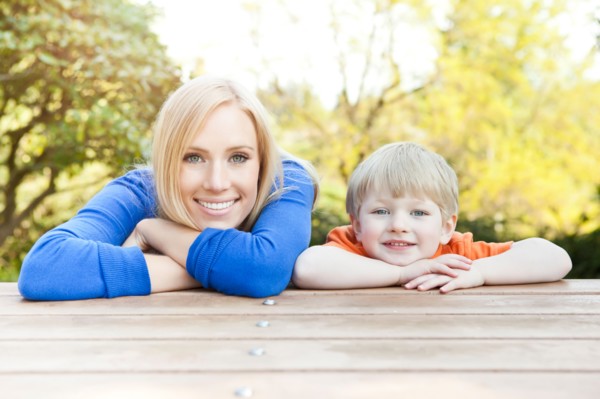 Portrait of mother and son (2-3) leaning at picnic table. Photo : Take A Pix Media