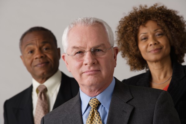Portrait of three business people, studio shot. Photo : Rob Lewine