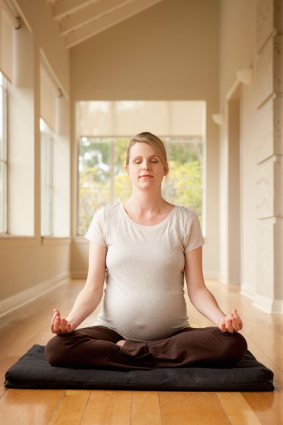 Pregnant woman practicing yoga. Photo : Rob Lewine
