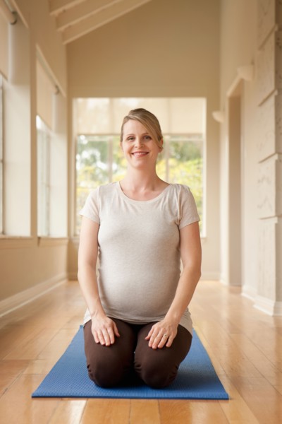 Pregnant woman practicing yoga. Photo : Rob Lewine
