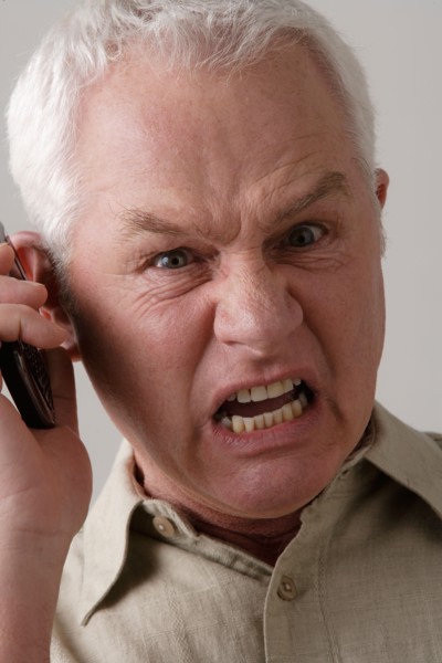 Portrait of angry senior man with mobile phone, studio shot. Photo : Rob Lewine