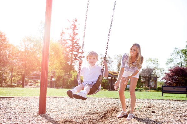 USA, Washington State, Seattle, Mother and son (2-3) swinging on swing in park. Photo : Take A Pix