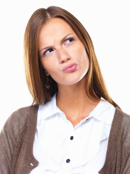Close-up of business woman in doubt pursing her lips and looking away. Photo : momentimages