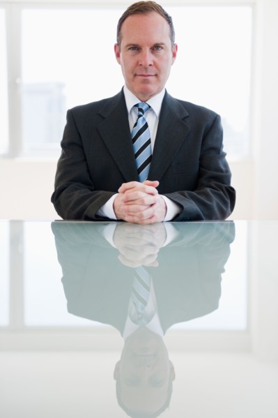Businessman sitting at table. Photo : Jamie Grill