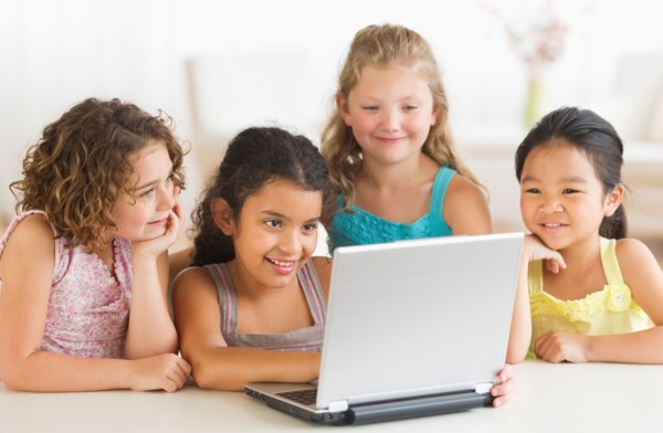 Four girls (6-9) using laptop.