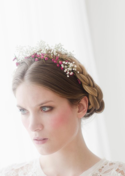 Pensive young woman with flowers in hair.