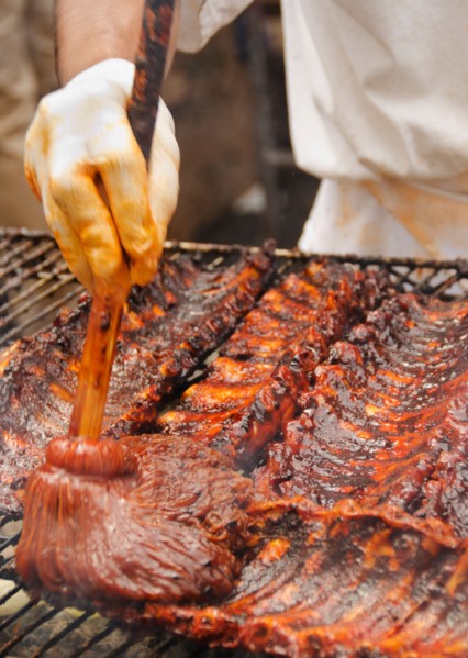 Chef cooking spareribs on barbeque.