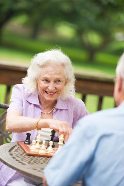 Seniors playing chess on porch.