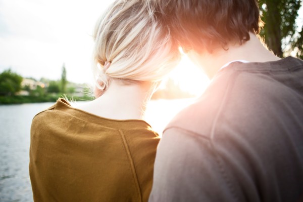 Rear view of young couple looking at sunset. Photo : Take A Pix Media