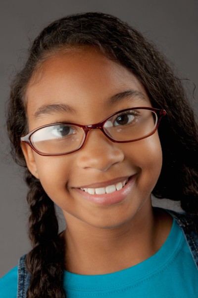 Studio portrait of girl (8-9) wearing eyeglasses. Photo: Rob Lewine