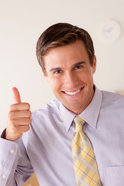 Portrait of businessman with thumbs up. Photo : Rob Lewine