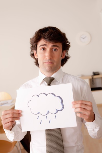 Studio portrait of businessman holding sheet of paper with cloud drawing. Photo: Rob Lewine