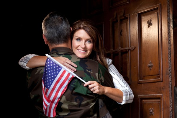 Soldier with wife embracing. Photo : db2stock