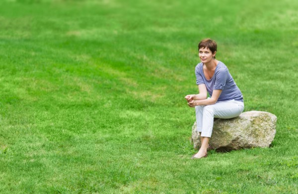 Mature woman sitting on rock.