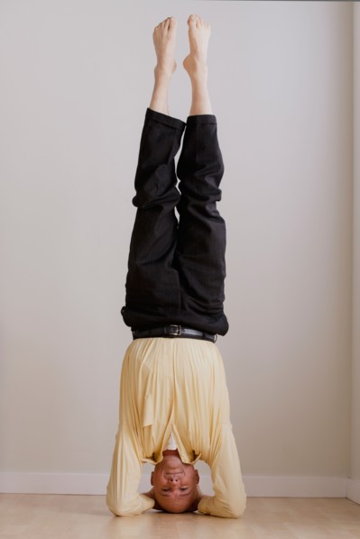 Mature businessman doing headstand. Photo : Rob Lewine