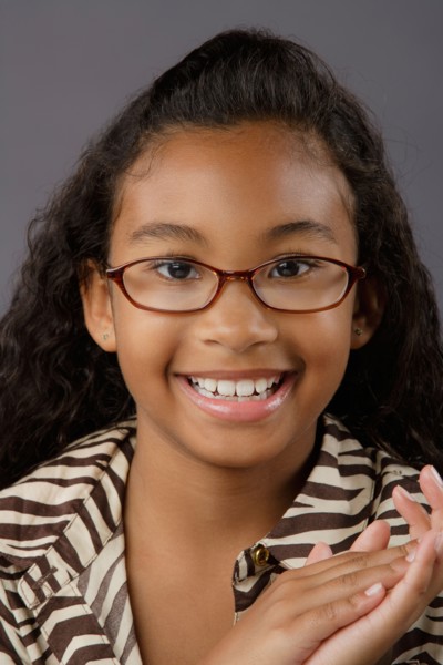 Portrait of smiling girl (8-9), studio shot. Photo: Rob Lewine
