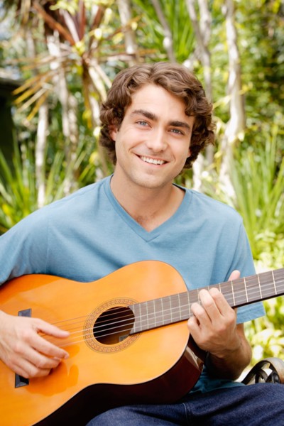 Portrait of young man playing guitar. Photo : Rob Lewine