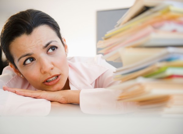 Businesswoman overworked with paperwork. Photo : Jamie Grill