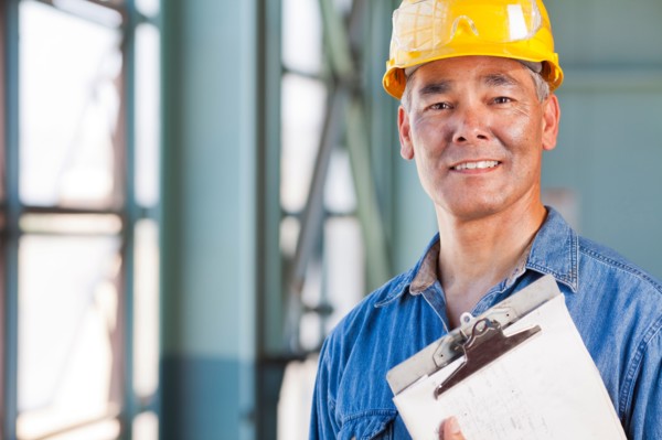 Portrait of man wearing hardhat holding clipboard. Photo : db2stock