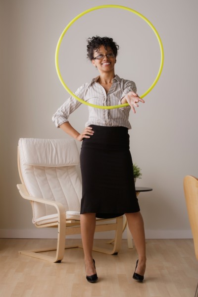 Young businesswoman using hoola hoop. Photo: Rob Lewine