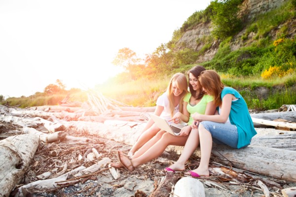 Three young women hanging out on beach. Photo : Take A Pix Media