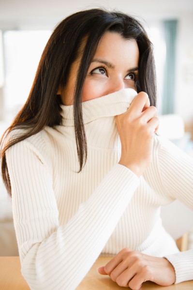 Portrait of woman covering face with turtle neck. Photo: Jamie Grill