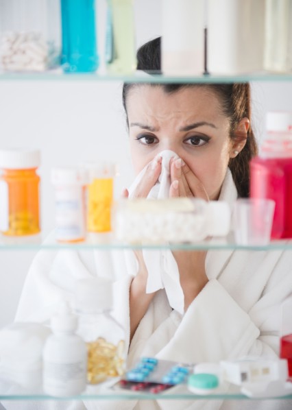 Woman sneezing and using tissue. Photo: Jamie Grill