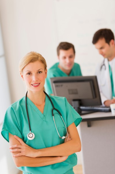 Portrait of female doctor in front of nurse's station.