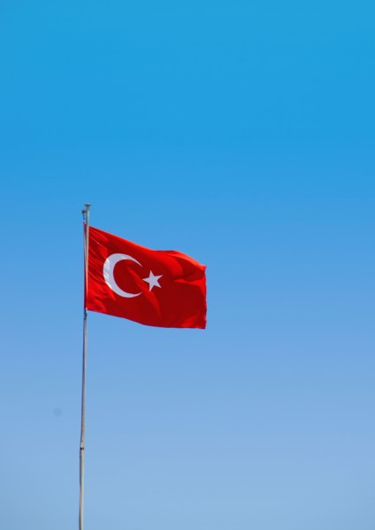 Turkey, Turkish flag against blue sky. Photo : Tetra Images