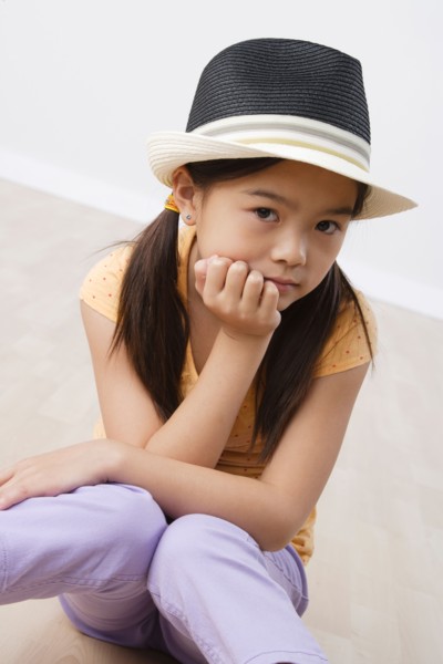 Studio portrait of girl (8-9) wearing hat. Photo: Rob Lewine