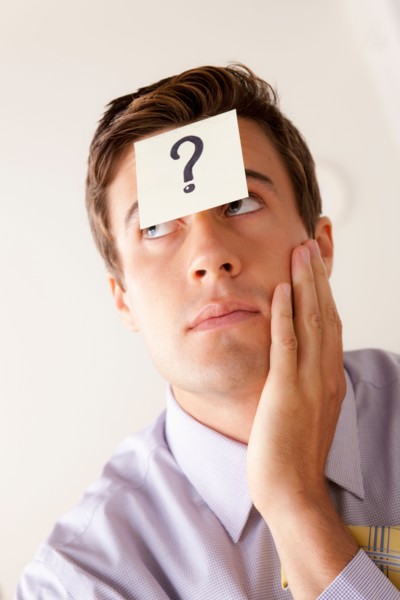 Portrait of businessman with adhesive note attached on forehead. Photo: Rob Lewine