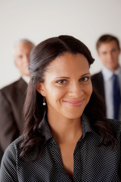 Studio shot of business people, focus on mid adult business woman. Photo : Rob Lewine