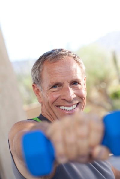 Portrait of senior man lifting dumbbells. Photo : db2stock