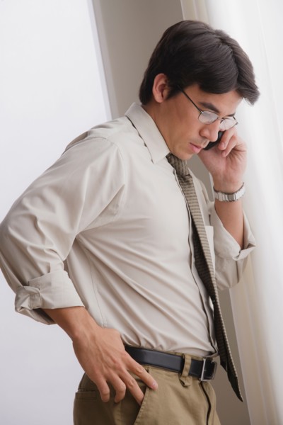 Young businessman using cell phone. Photo: Rob Lewine
