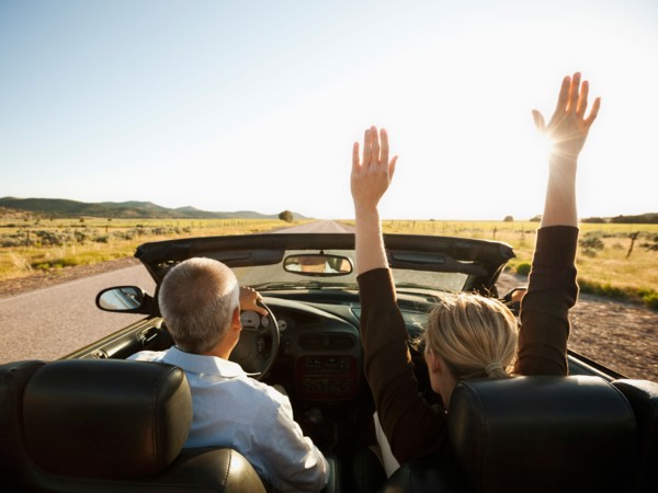USA, Utah, Kanosh, Mad-adult couple driving through desert plains in convertible car. Photo: Erik