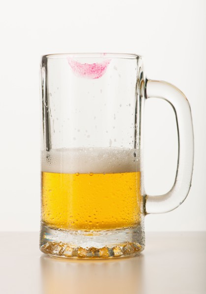 Lipstick on beer glass, studio shot.
