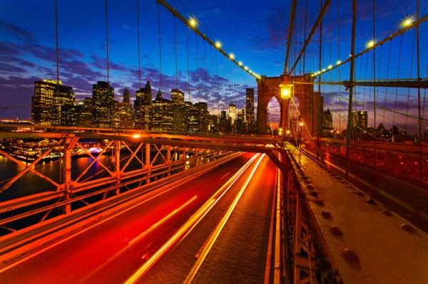 USA, New York City, Brooklyn Bridge with light trails at dusk.