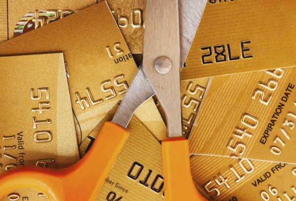 Scissors on pile of credit cards, studio shot.
