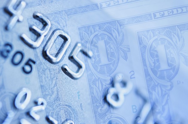 Credit card and dollar bills, studio shot.