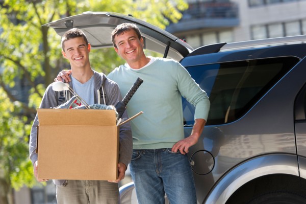 Father helping teenage son (16-17) packing to college.