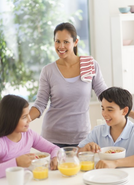Mother with son (12-13) and daughter (10-11) having breakfast.