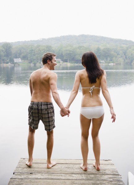 USA, New York, Putnam Valley, Roaring Brook Lake, Couple standing on pier by lake. Photo : Jamie