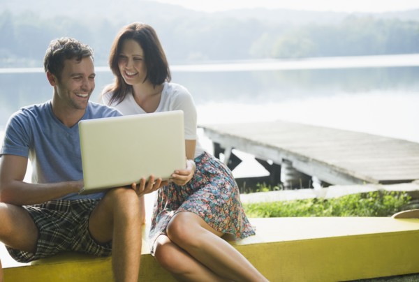 Roaring Brook Lake, Couple using laptop by lake. Photo : Jamie Grill