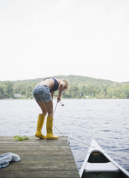 USA, New York, Putnam Valley, Roaring Brook Lake, Rear view of woman mooring boat. Photo : Jamie